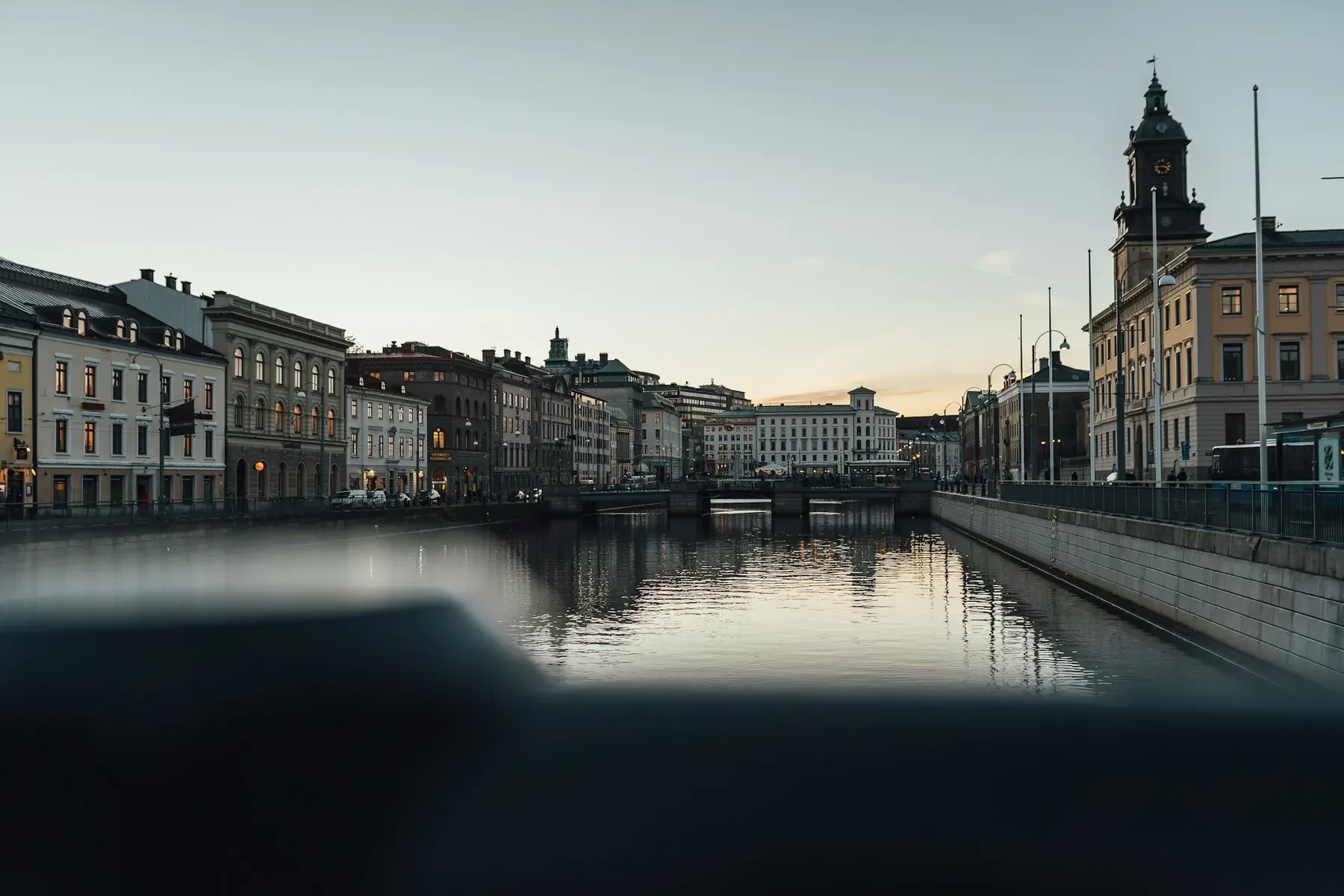 Stora Hamnkanalen i Göteborg i kvällsljus, med stenhus längs kajen och ett klocktorn till höger.